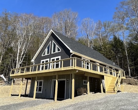 Completed modular chalet home in the Boston New York hills shows an optional wrap around porch and garage in the basement.